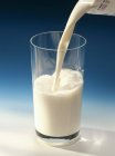 Versando il latte nel vetro — Foto stock