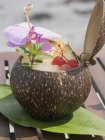 Opened coconut with mint and orchid — Stock Photo