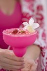 Nahaufnahme beschnitten Ansicht der Frau mit Getränk mit Erdbeeren und Blume — Stockfoto