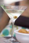 Martini mit grünen Oliven und Crackern — Stockfoto