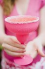 Vista da vicino della donna che tiene il bicchiere da cocktail rosa con bordo zuccherato — Foto stock