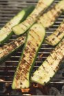 Slices of courgette on a barbecue grill rack — Stock Photo