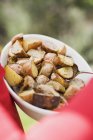 Roasted rosemary potatoes in dish with spoon — Stock Photo