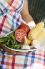 Person hält Teller mit Gemüse — Stockfoto