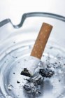 Vista de close-up de fim de cigarro em um cinzeiro — Fotografia de Stock