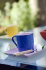 Vue de jour de tasses colorées avec du sucre sur la table à l'extérieur — Photo de stock