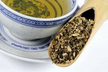 Patchouli herb in scoop with a cup of tea — Stock Photo
