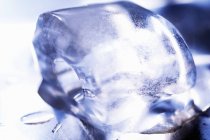 Vue rapprochée d'un cube de glace en fusion sur une surface métallique — Photo de stock