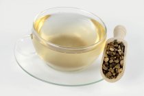 Xícara de chá com raiz de noz-grama seca — Fotografia de Stock