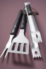 Closeup top view of barbecue tools on light-brown surface — Stock Photo