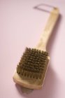 Vista close-up de uma escova de arame na superfície bege — Fotografia de Stock