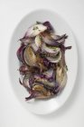 Grilled red onions on white platter — Stock Photo