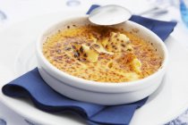 Closeup view of Creme brulee in bowl with spoon and napkin — Stock Photo