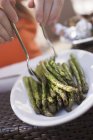 Mani umane che prendono asparagi alla griglia — Foto stock