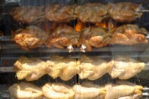 Vista de cerca de pollos a la parrilla en escupitajos - foto de stock