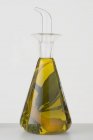 Vista de close-up de óleo de ervas com casca de limão em uma garrafa — Fotografia de Stock