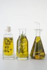 Primo piano vista di tre diversi oli di erbe in bottiglie — Foto stock