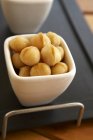 Cuenco de nueces de macadamia - foto de stock
