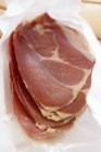 Slices of Parma ham on paper — Stock Photo