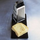 Parmigiano con grattugia sulla scrivania — Foto stock