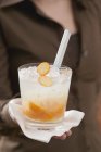 Donna che tiene cocktail con kumquat — Foto stock