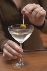 Bar tender offering glass of martini — Stock Photo