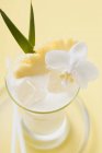 Vista close-up de coquetel Pina Colada com abacaxi e orquídea branca — Fotografia de Stock