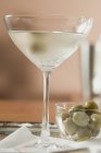 Martini con olive e ciotola con olive verdi — Foto stock