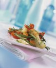 Gemüse mit Thymian auf weißem Teller über Handtuch anbraten — Stockfoto