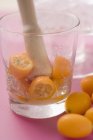 Crushing kumquats in a glass — Stock Photo