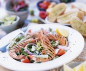 Крупним планом вид на смажені креветки на овочевому салаті з травою багет — стокове фото