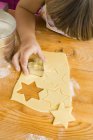 Child cutting biscuits — Stock Photo