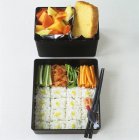 Sushi, vegetables, fruit salad and cake — Stock Photo