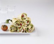 Gestapelte Gemüsewickel auf weißem Teller über weißer Oberfläche — Stockfoto