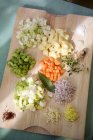 Vista elevata di verdure tritate, erbe e pancetta su una tavola di legno — Foto stock