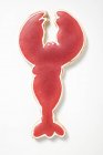 Вид крупным планом печенья в форме омаров с красной глазурью на белой поверхности — стоковое фото