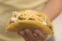Hand holding taco — Stock Photo