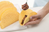 Filling tacos by spoon — Stock Photo