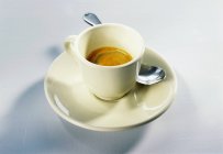 Cup of espresso with saucer and spoon — Stock Photo