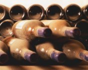 Empilés vieilles bouteilles de vin dans la poussière — Photo de stock