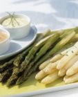 Green and white asparagus with sauces — Stock Photo
