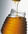 Miel dans un bocal avec cuillère — Photo de stock