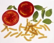 Nudeln mit Fusilli, Tomatenscheiben und Basilikum — Stockfoto