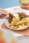 Hand dipping tortilla — Stock Photo