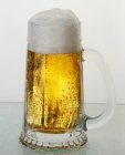Tankard of lager on table — Stock Photo