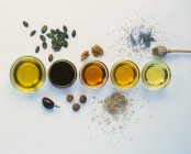 Vue de dessus de différents types d'huile avec des ingrédients bruts — Photo de stock