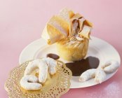 Closeup view of cream strudel with chocolate sauce and vanilla crescents — Stock Photo