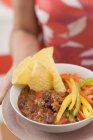 Frau serviert Chili con Carne — Stockfoto