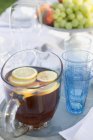 Iced tea with slices of lemon in jug — Stock Photo