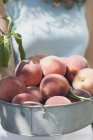 Женщина со свежими персиками — стоковое фото